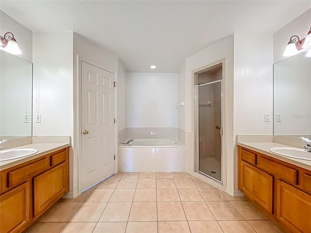 16634 Pine Timber Ave, Montverde, FL 34756 - bathroom featuring two vanities, a bath, tile patterned floors, a shower stall, and recessed lighting