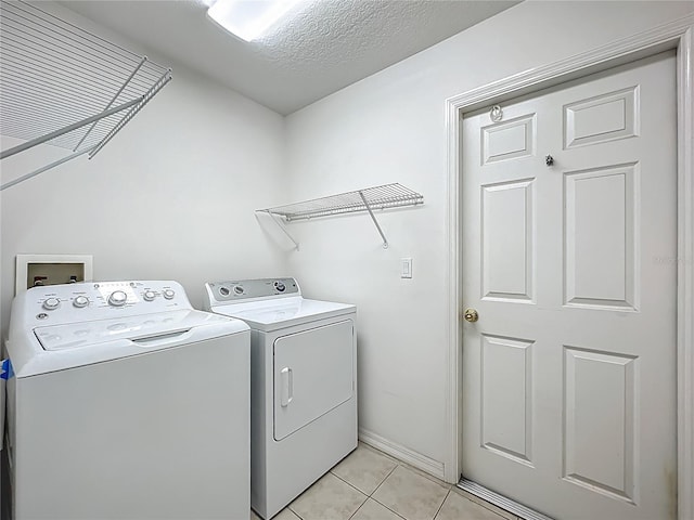 16634 Pine Timber Ave, Montverde, FL 34756 - laundry area with washing machine and clothes dryer, light tile patterned floors, and a textured ceiling