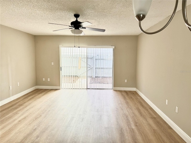6054 Amberly Ct Unit T21, Orlando, FL 32822 - empty room with wood finished floors, a ceiling fan, and a textured ceiling