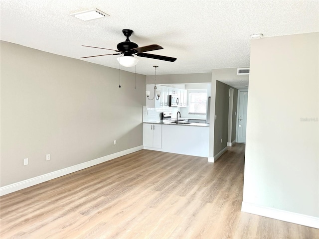 6054 Amberly Ct Unit T21, Orlando, FL 32822 - unfurnished living room with ceiling fan, light wood-style flooring, and a textured ceiling