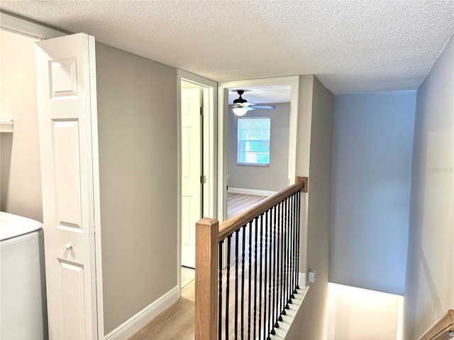 6054 Amberly Ct Unit T21, Orlando, FL 32822 - hallway with a textured ceiling, light wood-type flooring, an upstairs landing, and washer / clothes dryer