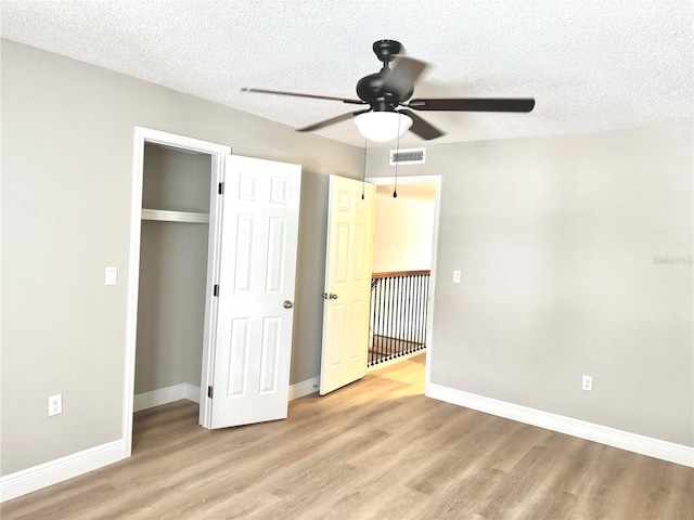 6054 Amberly Ct Unit T21, Orlando, FL 32822 - unfurnished bedroom featuring light wood-style floors, a textured ceiling, a closet, and ceiling fan