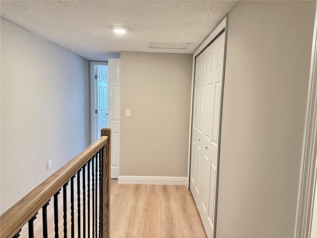 6054 Amberly Ct Unit T21, Orlando, FL 32822 - corridor featuring light wood-style flooring, a textured ceiling, and an upstairs landing