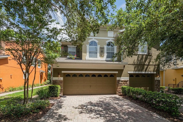 5072 Cypress Branch Pt, Oviedo, FL 32765 - view of front of home featuring stucco siding, an attached garage, stone siding, and decorative driveway