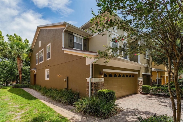 5072 Cypress Branch Pt, Oviedo, FL 32765 - townhome / multi-family property with an attached garage, stucco siding, stone siding, and decorative driveway