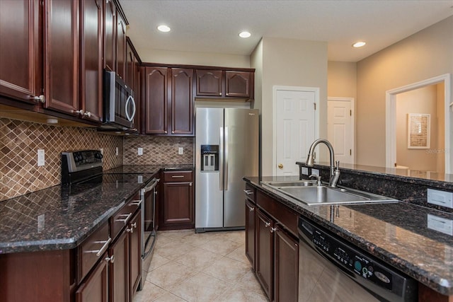 5072 Cypress Branch Pt, Oviedo, FL 32765 - kitchen with stainless steel appliances, decorative backsplash, light tile patterned floors, dark stone countertops, and dark brown cabinets