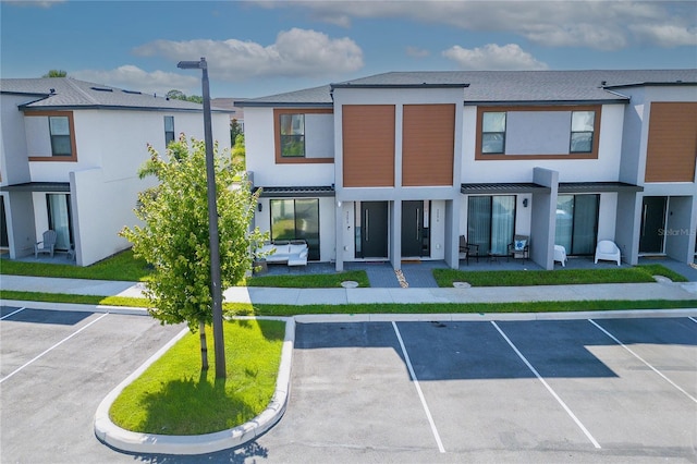 3292 Tranquil Trl, Kissimmee, FL 34747 - view of front of property featuring uncovered parking, stucco siding, and a patio area