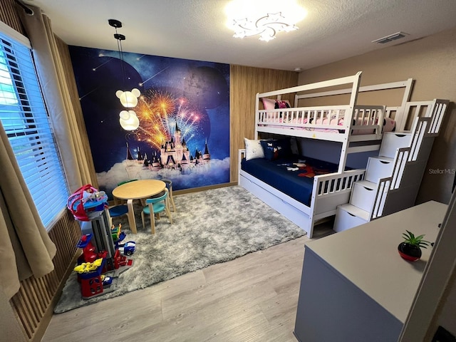 3292 Tranquil Trl, Kissimmee, FL 34747 - bedroom with wood finished floors, an accent wall, and a chandelier