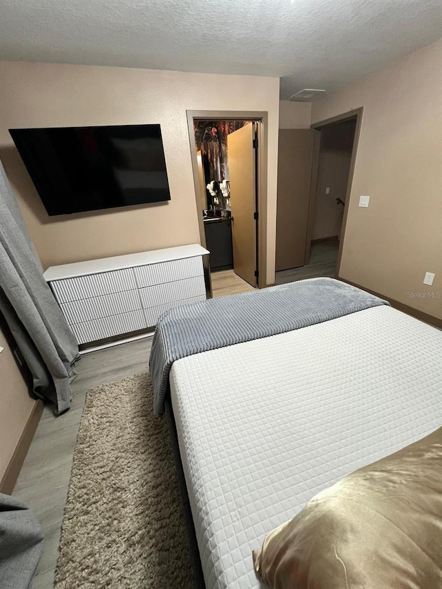 3292 Tranquil Trl, Kissimmee, FL 34747 - bedroom featuring light wood-style floors, a textured ceiling, and a spacious closet