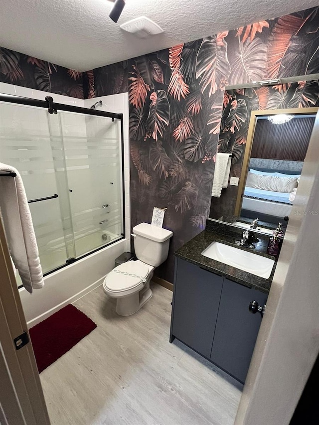 3292 Tranquil Trl, Kissimmee, FL 34747 - bathroom featuring wallpapered walls, a textured ceiling, enclosed tub / shower combo, wood finished floors, and vanity