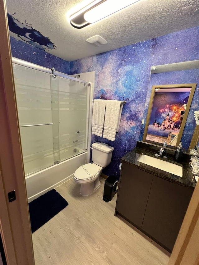 3292 Tranquil Trl, Kissimmee, FL 34747 - full bathroom featuring a textured ceiling, wood finished floors, vanity, bath / shower combo with glass door, and wallpapered walls