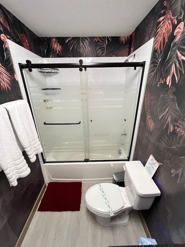 3292 Tranquil Trl, Kissimmee, FL 34747 - bathroom with wood finished floors, bath / shower combo with glass door, and a textured ceiling