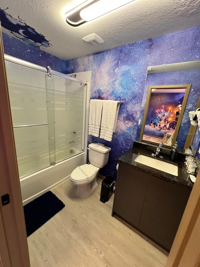 3292 Tranquil Trl, Kissimmee, FL 34747 - full bathroom featuring a textured ceiling, wood finished floors, vanity, bath / shower combo with glass door, and wallpapered walls