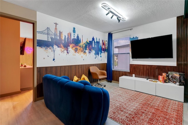 3292 Tranquil Trl, Kissimmee, FL 34747 - living area with wainscoting, a textured ceiling, wood finished floors, and wood walls
