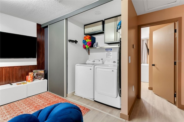 3292 Tranquil Trl, Kissimmee, FL 34747 - washroom with light wood finished floors, washing machine and dryer, and a textured ceiling