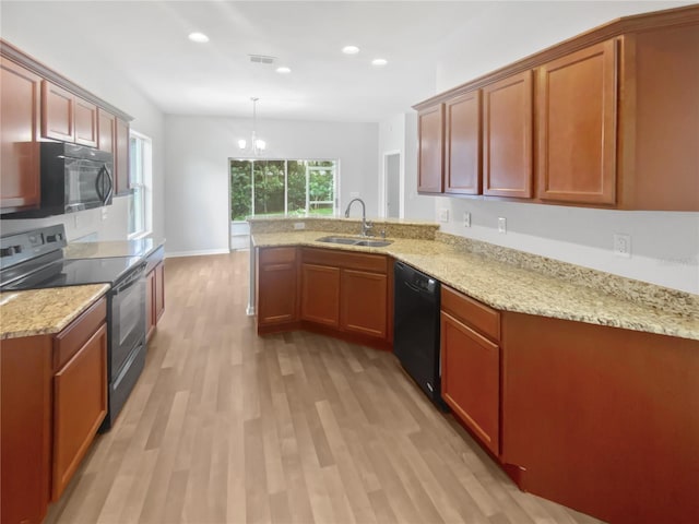 6303 Twin Bridges Dr, Zephyrhills, FL 33541 - kitchen featuring black appliances, a peninsula, light wood-style flooring, light stone countertops, and recessed lighting