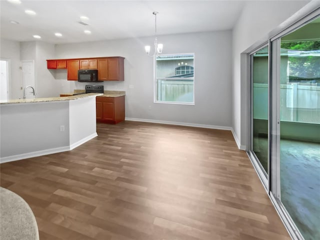 6303 Twin Bridges Dr, Zephyrhills, FL 33541 - kitchen featuring black microwave, electric stove, brown cabinets, recessed lighting, and wood finished floors