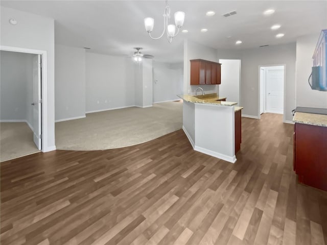 6303 Twin Bridges Dr, Zephyrhills, FL 33541 - kitchen with a ceiling fan, a chandelier, a peninsula, wood finished floors, and recessed lighting
