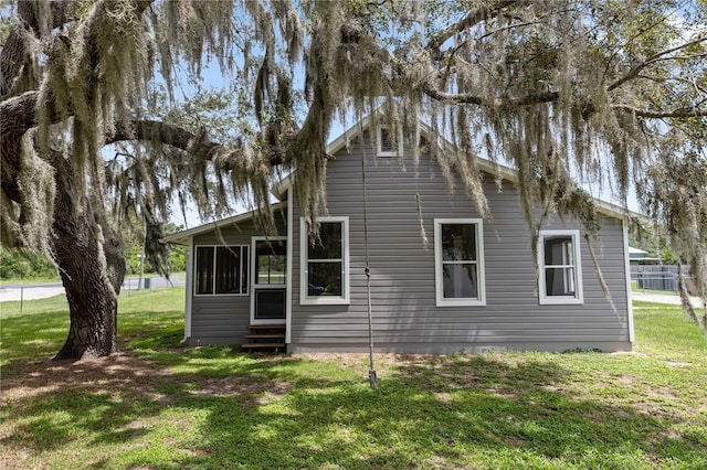 19402 E 5th St, Umatilla, FL 32784 - back of house with entry steps, a yard, and a sunroom