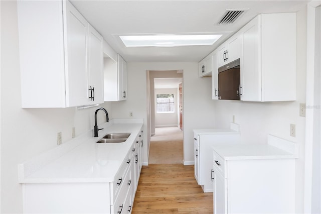 19402 E 5th St, Umatilla, FL 32784 - kitchen featuring light wood-style floors, light countertops, and white cabinetry