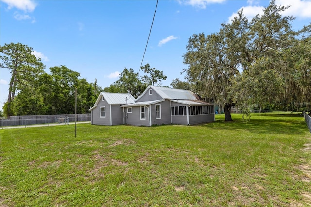 19402 E 5th St, Umatilla, FL 32784 - back of property with a sunroom, a fenced backyard, and a metal roof