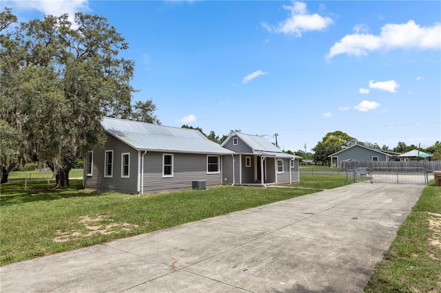 19402 E 5th St, Umatilla, FL 32784 - single story home with a metal roof, driveway, and a gate