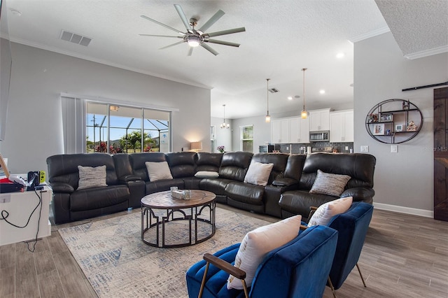 8998 Croquet Ct, Champions Gate, FL 33896 - living room featuring light wood-type flooring, healthy amount of natural light, ceiling fan, crown molding, and a textured ceiling