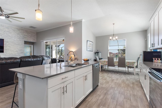 8998 Croquet Ct, Champions Gate, FL 33896 - kitchen featuring appliances with stainless steel finishes, open floor plan, light wood-style flooring, a chandelier, and ornamental molding