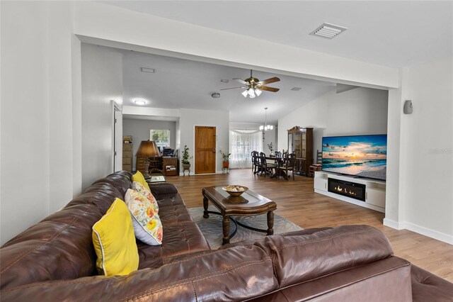 12404 SW 31st Ave, Archer, FL 32618 - living room featuring wood finished floors, lofted ceiling, a ceiling fan, and a glass covered fireplace