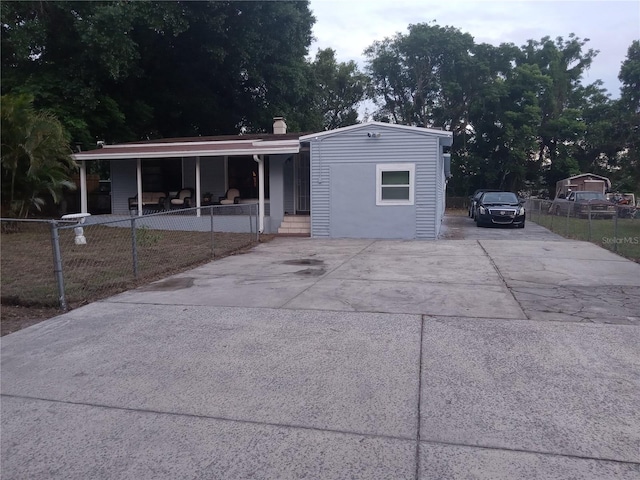 1624 Grand St, Orlando, FL 32805 - view of front of house with covered porch, concrete driveway, and a chimney