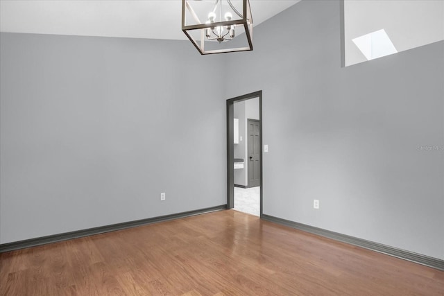 1237 Erik Ct, Altamonte Springs, FL 32714 - unfurnished room featuring high vaulted ceiling, a chandelier, wood finished floors, and a skylight