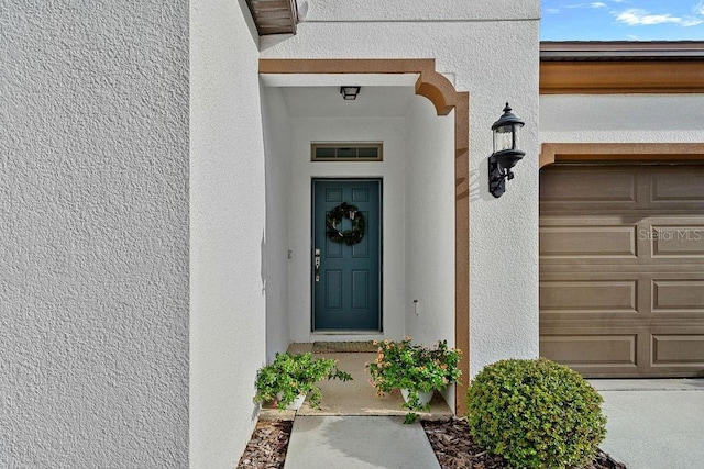 1193 Woods Landing Dr, Minneola, FL 34715 - view of exterior entry featuring stucco siding and an attached garage