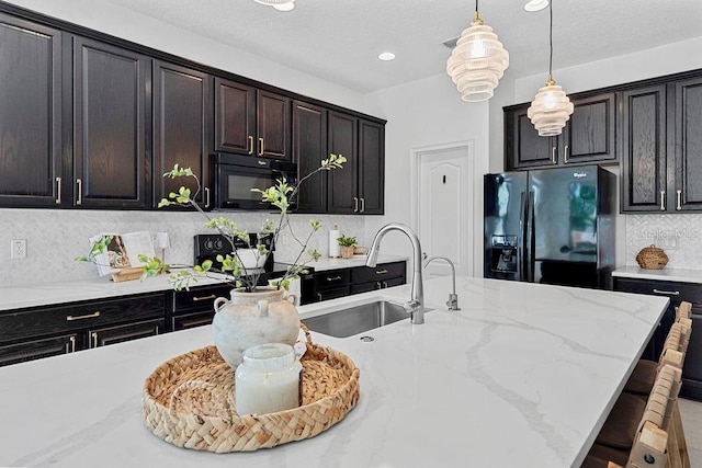1193 Woods Landing Dr, Minneola, FL 34715 - kitchen with black appliances, pendant lighting, backsplash, light stone countertops, and recessed lighting