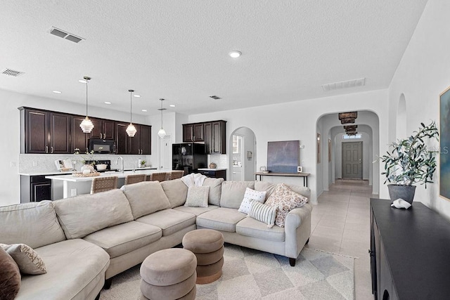 1193 Woods Landing Dr, Minneola, FL 34715 - living area with arched walkways, a textured ceiling, and recessed lighting