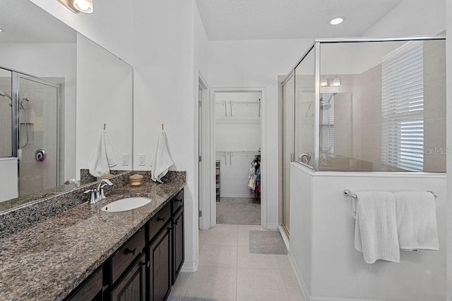 1193 Woods Landing Dr, Minneola, FL 34715 - full bathroom featuring vanity, tile patterned flooring, a shower stall, and a walk in closet