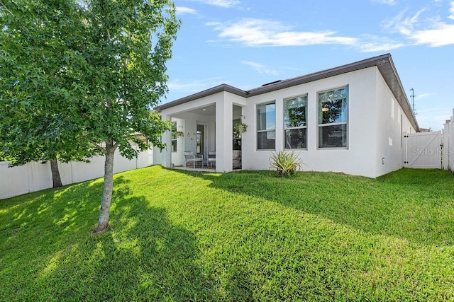 1193 Woods Landing Dr, Minneola, FL 34715 - rear view of property with stucco siding, a fenced backyard, and a gate
