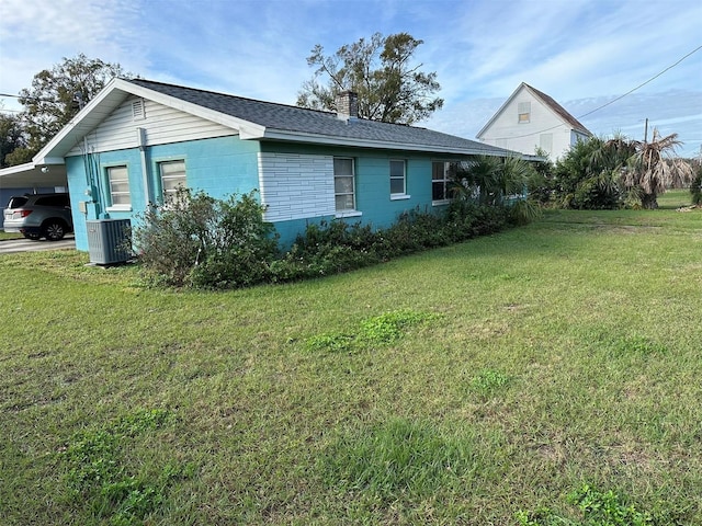 511 Pilaklakaha Ave, Auburndale, FL 33823 - view of side of property featuring a chimney, a lawn, a carport, and roof with shingles