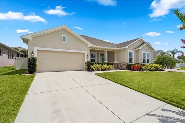 16415 Good Hearth Blvd, Clermont, FL 34711 - view of front of home with stucco siding, stone siding, an attached garage, and driveway
