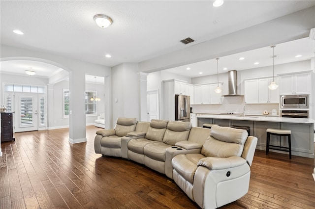 16415 Good Hearth Blvd, Clermont, FL 34711 - living room featuring decorative columns, arched walkways, dark wood finished floors, and recessed lighting
