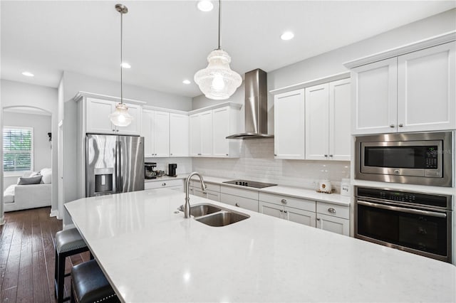 16415 Good Hearth Blvd, Clermont, FL 34711 - kitchen with stainless steel appliances, wall chimney range hood, a breakfast bar area, backsplash, and decorative light fixtures