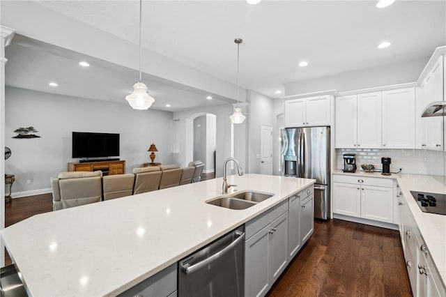 16415 Good Hearth Blvd, Clermont, FL 34711 - kitchen with appliances with stainless steel finishes, arched walkways, recessed lighting, dark wood finished floors, and decorative backsplash