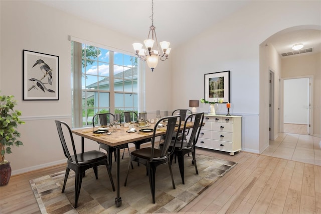 6029 Falconbridge Pl, Mount Dora, FL 32757 - dining room featuring arched walkways, a chandelier, and light wood-style floors