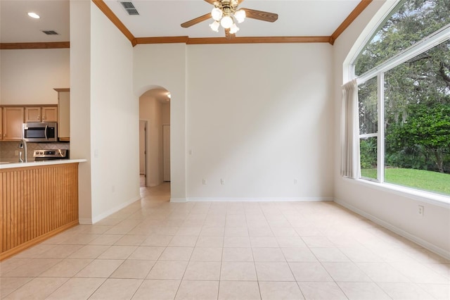 6029 Falconbridge Pl, Mount Dora, FL 32757 - unfurnished living room featuring arched walkways, a ceiling fan, crown molding, and light tile patterned flooring