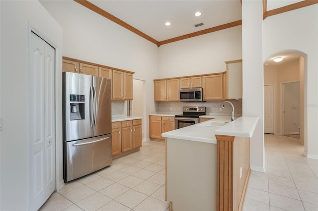 6029 Falconbridge Pl, Mount Dora, FL 32757 - kitchen with stainless steel appliances, light tile patterned floors, arched walkways, a high ceiling, and backsplash