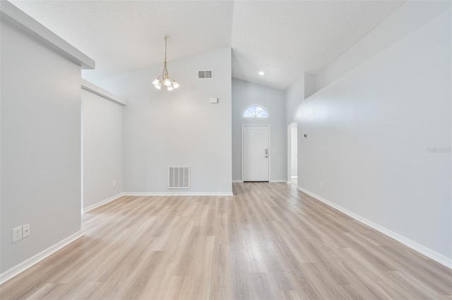 313 Cheshire Way, Davenport, FL 33897 - empty room featuring a chandelier, light wood-type flooring, and high vaulted ceiling
