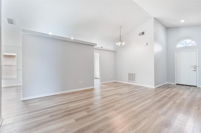 313 Cheshire Way, Davenport, FL 33897 - unfurnished living room with a chandelier, light wood-type flooring, lofted ceiling, a textured ceiling, and recessed lighting