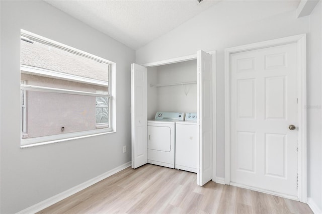 313 Cheshire Way, Davenport, FL 33897 - laundry area featuring washer and dryer, light wood-style flooring, and a textured ceiling