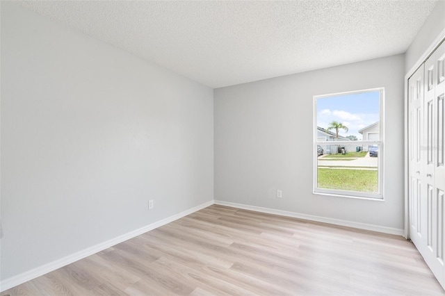 313 Cheshire Way, Davenport, FL 33897 - empty room with light wood-type flooring and a textured ceiling
