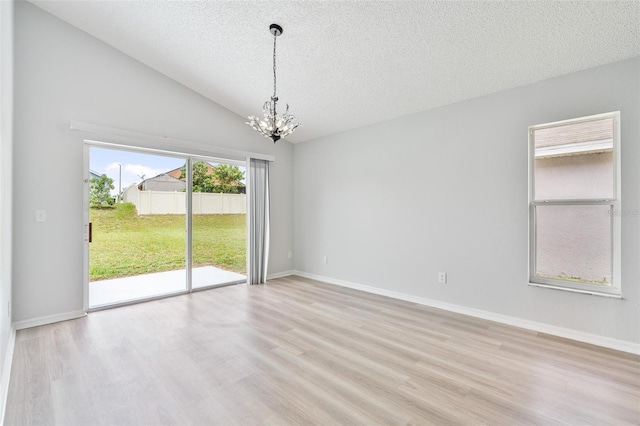 313 Cheshire Way, Davenport, FL 33897 - empty room with a chandelier, a textured ceiling, light wood-style floors, and lofted ceiling