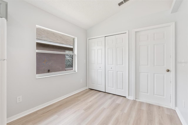313 Cheshire Way, Davenport, FL 33897 - unfurnished bedroom featuring wood finished floors, vaulted ceiling, a closet, and freestanding refrigerator